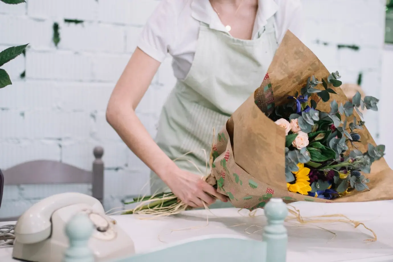 Mitarbeiter, der im Geschäft einen Blumenstrauß zusammenstellt